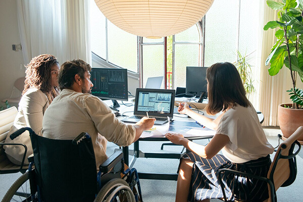 People sitting around a table viewing computers