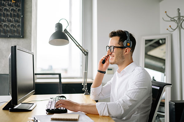 Man with headset using a computer